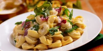 Tortellini com cebola e rúcula
