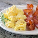 ovos mexidos com bacon para café da manhã tudo gostoso