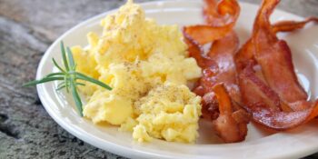 Ovos mexidos com bacon para café da manhã