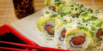 sushi uramaki com salmão e coberto com abacate