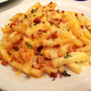 Batata frita com queijo cheddar derretido tudo gostoso
