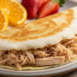 Crepioca recheada com frango e com frutas ao lado